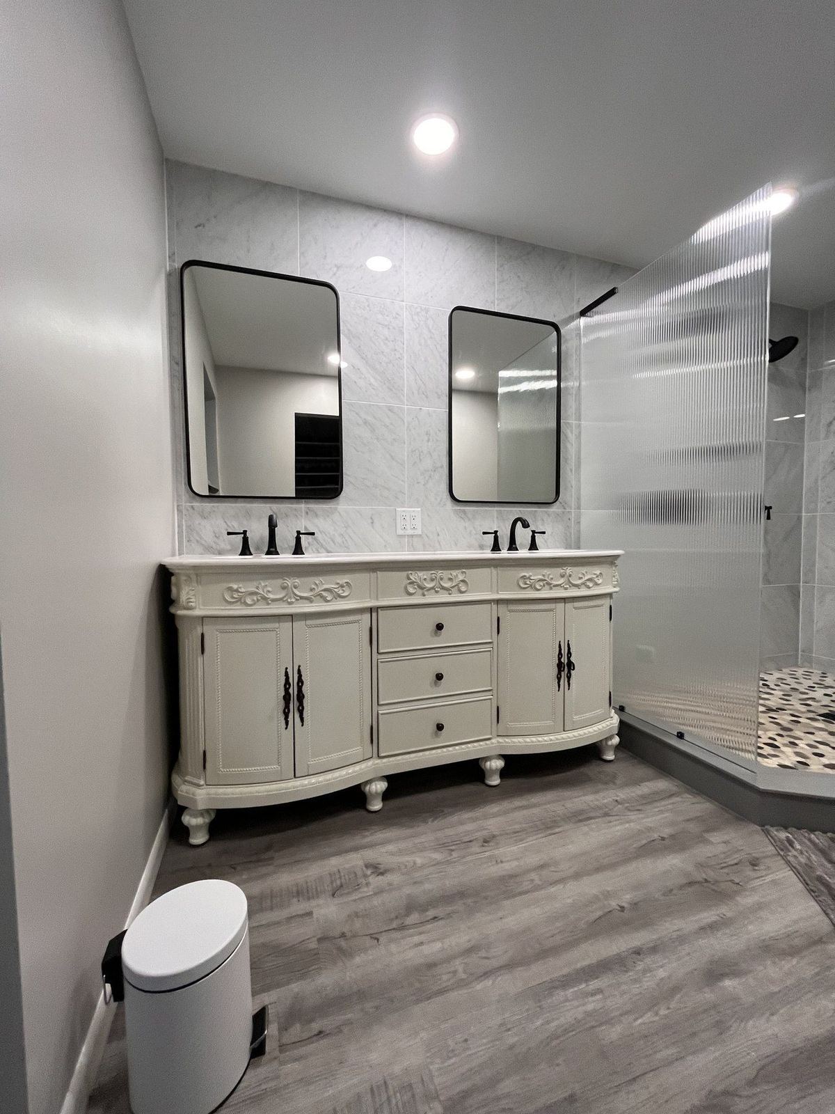 Double vanity with dual mirrors and marble tile wall