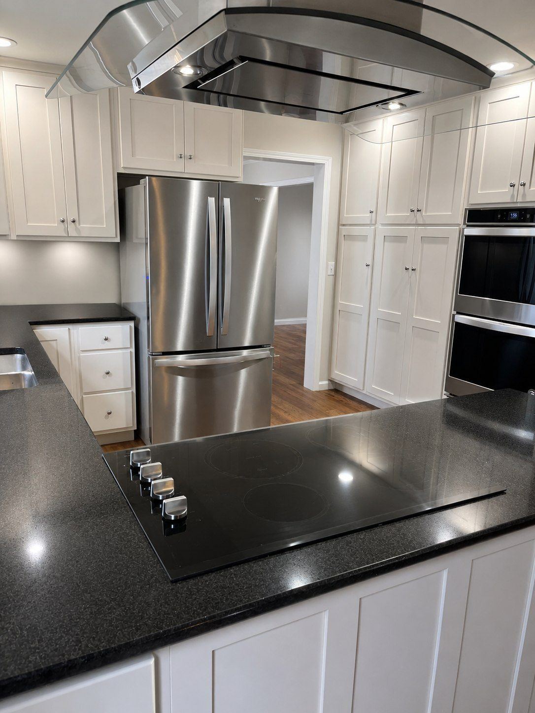 Kitchen remodel with glass range hood and quartz island by DK Dynamics