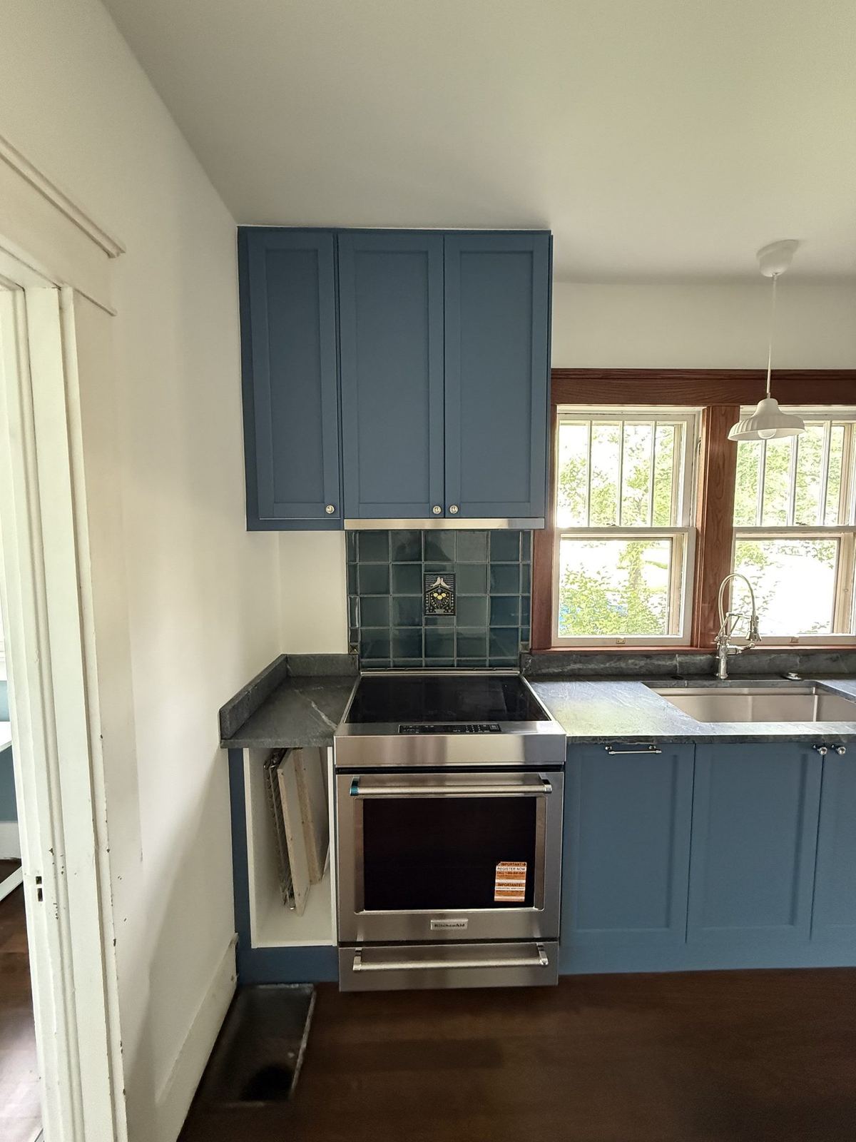 Zelmanovich kitchen after — blue cabinets, tile backsplash, soapstone countertops, new windows